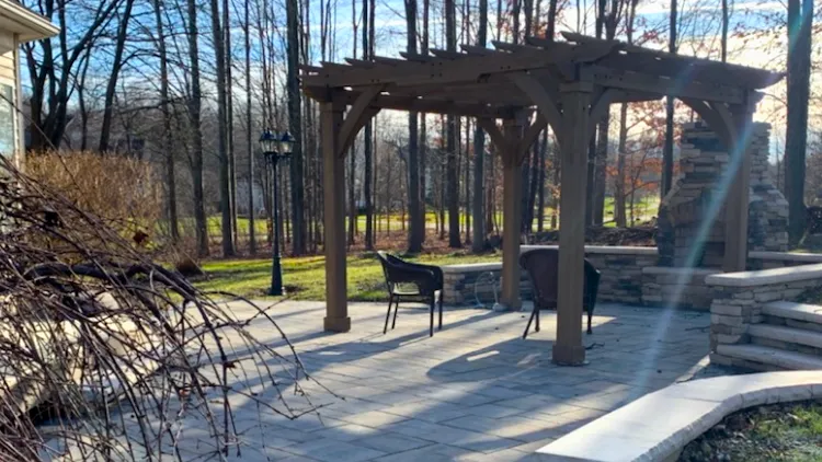Custom patio installation and outdoor living space construction in Auburn Township with natural stone hardscaping