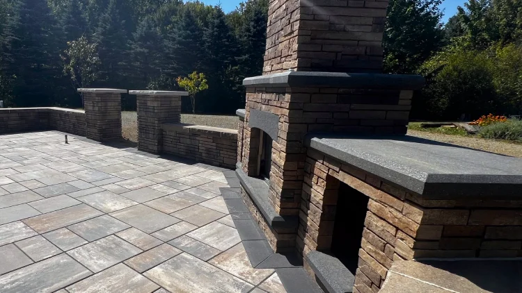 Outdoor fireplace with cut stone, natural stone patio and seating walls.