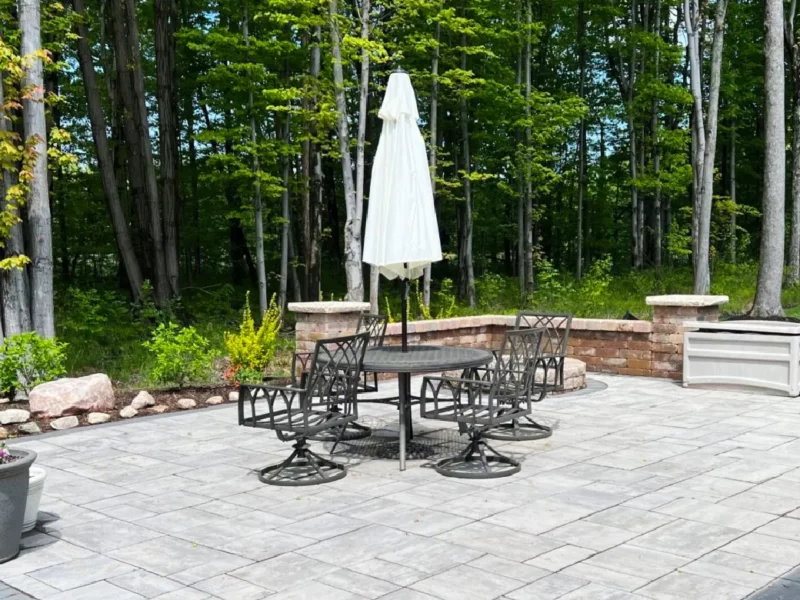 A professionally designed paver patio with natural stone in a wooded residential backyard, designed and built by Carmel Landscapes in Northest Ohio.