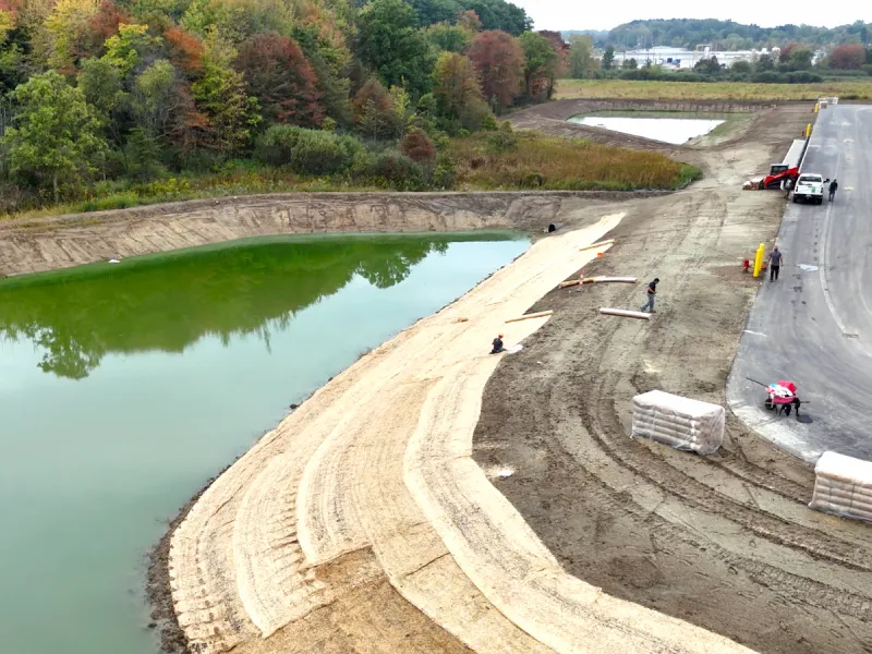 A commercial landscape development project with a pond and roadway designed and built with sustainable biophilic practices