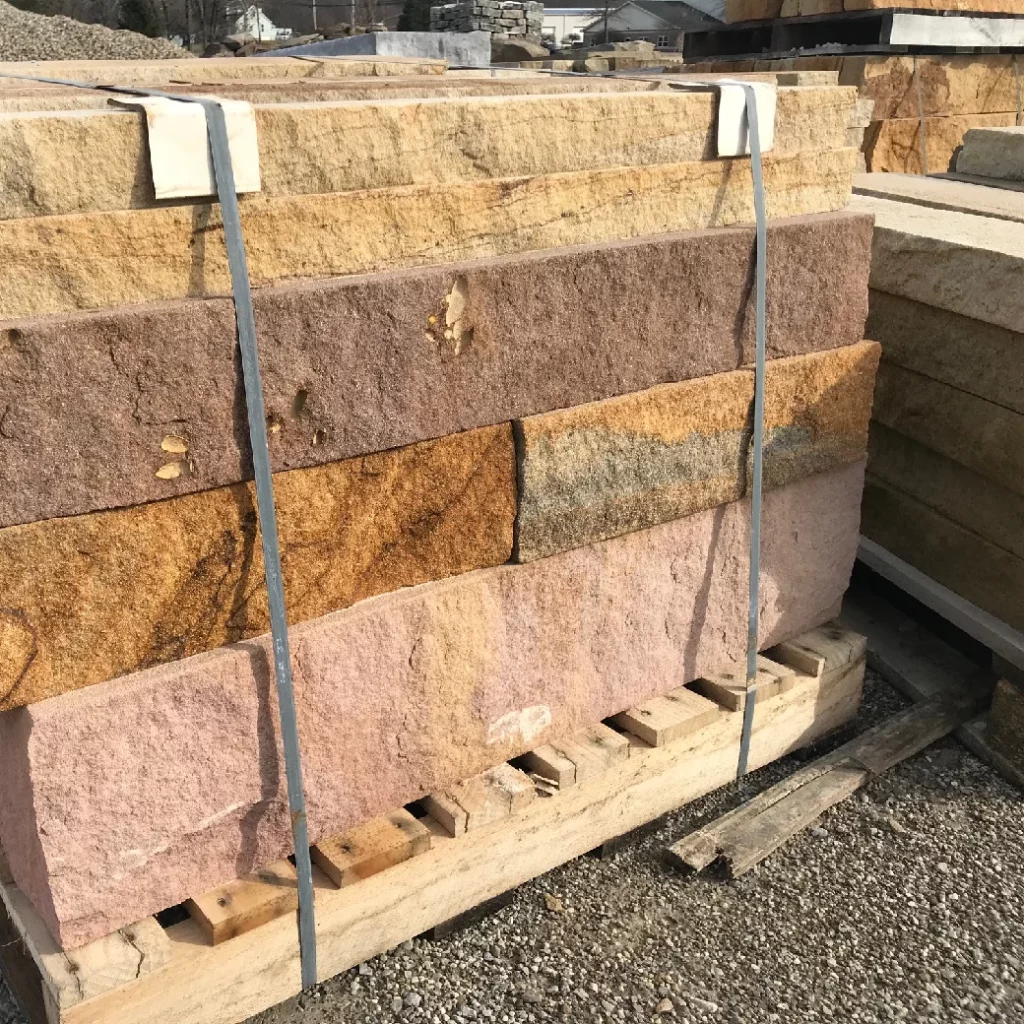 Natural stone blocks stacked in a supply yard used for hardscape installations and professional landscape design.
