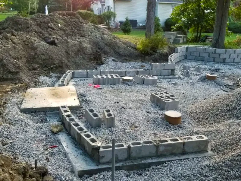 A new patio and retaining wall build with a custom outdoor fireplace in progress