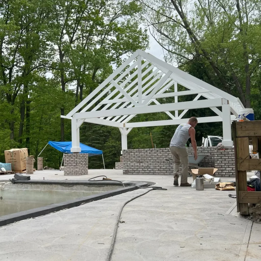 construction worker builds custom covered enclosure for a new outdoor kitchen and patio