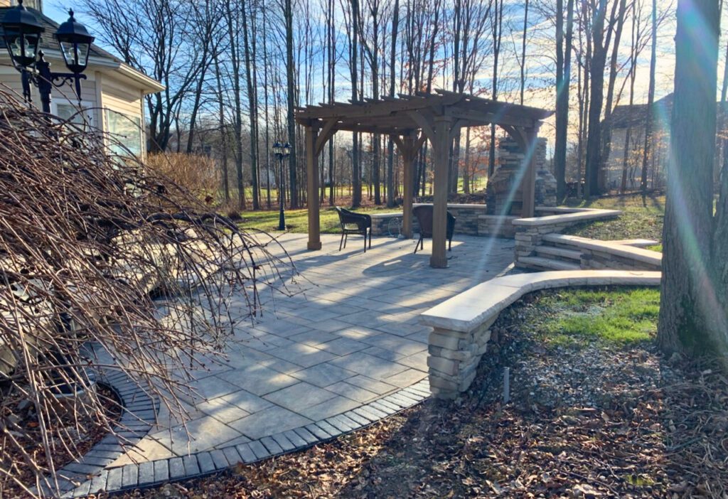 stone patio with natural stone wall, fireplace and pergola