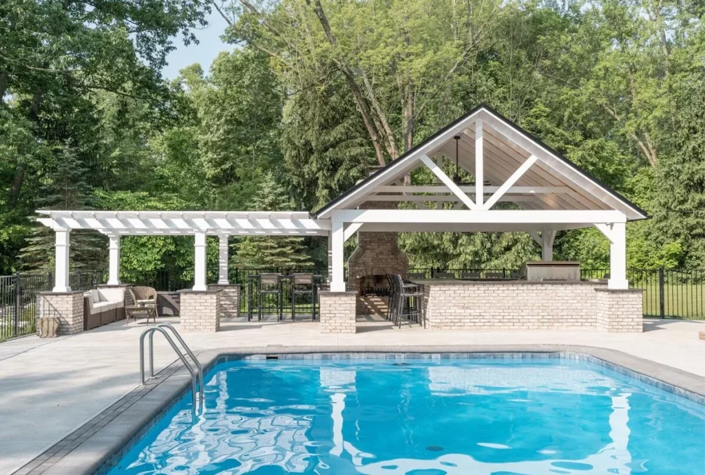 Pergola and pavilion construction over a custom patio pool deck, outdoor kitchen and seating area