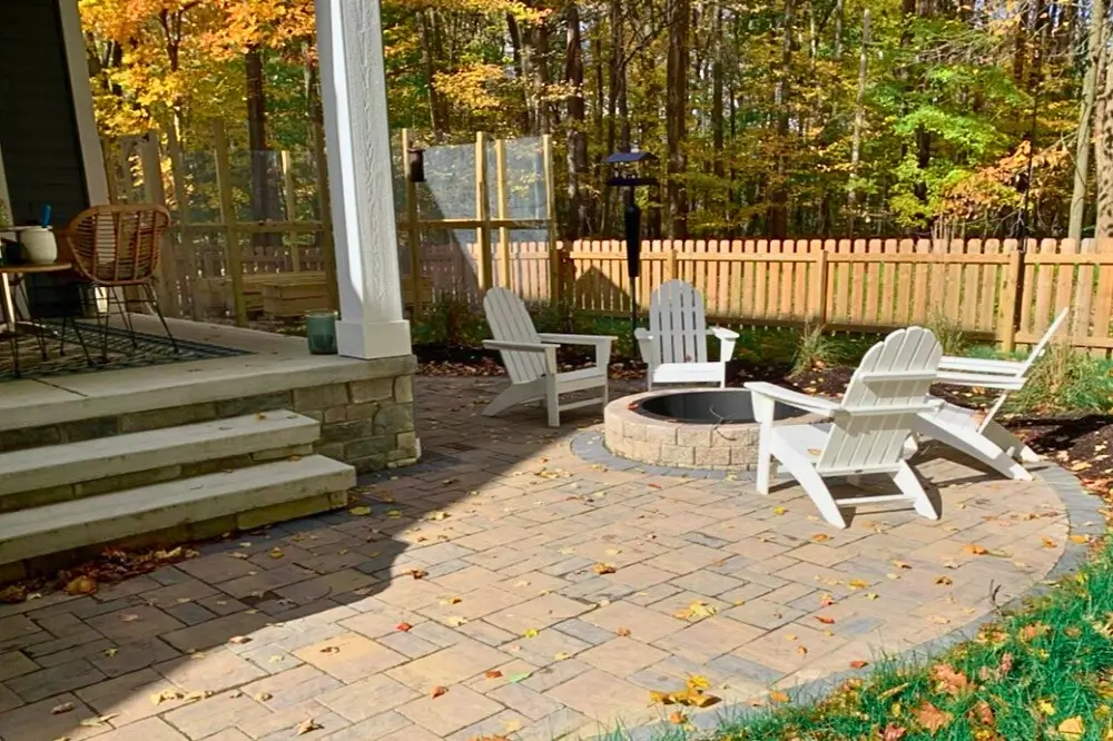 A stone patio and firepit construction in a backyard in Waite Hill designed and installed by Carmel Landscapes