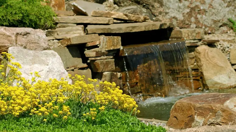 custom stone waterfall in a biophilic garden in ohio
